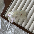 Close-up of acetic acid hair comb featuring colorful rhinestones and pearlescent texture - Off-white