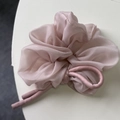 Dettaglio di scrunchie in organza rosa con nastro di raso per acconciature a coda alta - Rosa
