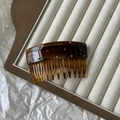 Detail of tortoiseshell acetate hair comb with colorful rhinestones on velvet display - Brown