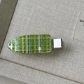 Macro shot of green checkered hair clip with fine glitter detail and silver metal base - Green