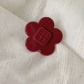 Vibrant red acetate flower hair clip with embossed letter pattern on a soft fabric background - Flower Style / Medium / Retro Copper