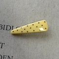 Detailed view of cheese yellow polka dot hair clip on a textured beige fabric background - Yellow Triangle