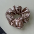 Detailansicht eines roségoldenen Satin-Haargummis mit funkelnden Strasssteinen und Kristallen - Champagnergold Haargummi
