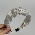 Détail du serre-tête en satin blanc avec strass brillants et décoration plissée chic - Serre-tête Blanc Cassé
