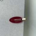 Macro detail of red acetate oval hair clip showing golden France Handmade lettering - Red
