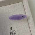 Detail einer lila karierten Haarklammer mit Herzkristall auf einem beigen Stofftablett - Violettes Oval