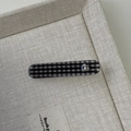 Detail der Haarklammer mit Karomuster und Herz-Strass auf beigefarbenem Tablett - Schwarz Rechteck