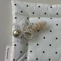 Detail der eleganten Perlen-Haarspange mit champagnergoldener Perle und Netzschleife - Beige Aprikose