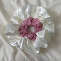 Detail eines großen rot-weißen Karo-Haargummis mit weichen Details aus cremefarbenem Satin - Rot Plaid Scrunchie