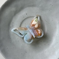 Detailansicht der Schmetterling-Haarklammer mit Marmormuster und goldenem Metallclip - Orange Blau