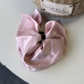 Detailed macro shot of a glossy pink satin scrunchie with smooth silk texture - Pink