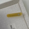 Detailed close-up of yellow checkered hair clip featuring a sparkling heart rhinestone - Yellow Rectangle