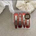 Detailed view of four amber brown resin drip hair clips in a branded handmade package - Red Coffee