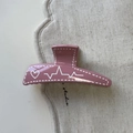 Détail de la pince à cheveux trapèze rose avec motif de cœur et ligne de pouls - Rose rouge