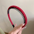 Dettaglio cerchietto intrecciato rosso con denti interni antiscivolo per acconciatura sicura - Rosso