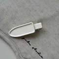 Close-up of a white matte rectangular hair clip on a minimalist textured fabric background - Off White