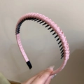 Detailed macro view of a pink braided headband with internal black grip teeth - Pink