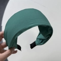 Nahaufnahme von smaragdgrünem Satin-Haarreifen mit gepolstertem Design und rutschfester Basis - Dunkelgrün