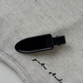Primer plano de una pinza para el pelo de metal negro brillante sobre fondo de lino beige - Negro