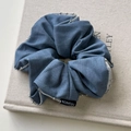 Dettaglio macro dell'elastico per capelli blu denim con bordo di perline e etichetta - Stile con Bordo di Perline Argentate / Blu Denim
