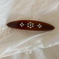 Detail of tortoise shell hair clip with crystal flowers on vintage white fabric - Brown