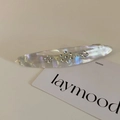 Détail d'une pince à cheveux fine en acétate avec motifs floraux en strass et texture nacre - Blanc Transparent
