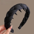 Detalle de diadema trenzada de satén negro mostrando dientes internos y textura de tela - Negro