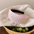 Detail eines rosa gepunkteten Stirnbands mit Faltenstoff und schwarzem rutschfestem Futter - Breiter Stil mit Punktmuster