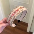 Detail eines böhmischen geflochtenen Haarreifs mit bunten Pailletten und Stickmustern - Braun