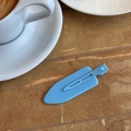 Dettaglio di un fermaglio per capelli blu opaco su un tavolo di caffè per fissare i capelli - Blu
