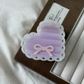 Detail view of heart-shaped acetate claw clip with pink bow and white lace edges - Aurora Purple