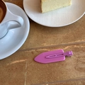 Close-up of matte lavender hair clip showing the metal back fastener on a textured surface - Purple
