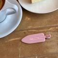 Close-up of a glossy pink candy-colored hair clip on a cozy cafe table setting - Pink