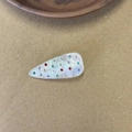 Elegant acetate teardrop hair clip with colorful rhinestones on a wooden tray background - White