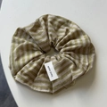Detailed macro view of olive green striped fabric scrunchie with hand made woven label - Hair Tie / Yellow