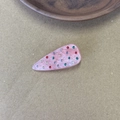 Detailed macro view of a pink marble acetate hair clip with colorful inlaid rhinestones - Pink
