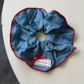 Detail eines blauen Denim-Haargummis mit rotem Rand, Spitze und Schleifenstickerei - Blaues Haargummi
