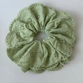 Dettaglio dell'elastico scrunchie verde chiaro con ricami traforati e bordi smerlati - Verde