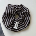 Detailed close-up of a black and grey striped fabric hair scrunchie with a Korea tag - Hair Tie / Black