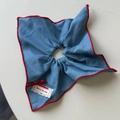 Detail von marineblauem Karo-Haargummi mit roten Nähten und Bonne Journée Spitzenetikett - Blaues quadratisches Tuch