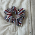 Gros plan sur la texture en maille à rayures colorées et l'étiquette en tissu du chouchou - Rouge Bleu Blanc / Petit