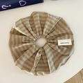 Detail of striped fabric scrunchie with a handmade tag in golden brown and light purple - Yellow Plaid