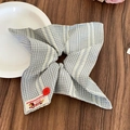 Dettaglio scrunchie a quadretti blu con bottone rosso e etichetta in tessuto - Blu
