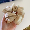 Close-up of oversized beige fabric scrunchie with pleated edge and twill texture detail - Beige Apricot