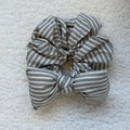 Detail of grey plaid sponge bow scrunchie with soft cotton texture on plush background - Black and White Striped Bow