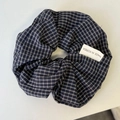 Detail of Korean style blue checkered hair scrunchie with a woven fabric label - Navy Plaid