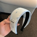 Detalle de la diadema a cuadros azules con bordado de lazo y forro antideslizante - Estilo Lazo