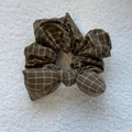 Close-up of retro green and brown plaid sponge bow scrunchie on soft plush surface - Yellow Coffee Plaid Bow