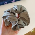 Close-up of oversized sage green pleated scrunchie with soft ribbed fabric texture - Grey Green