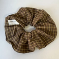 Macro detail van geruite scrunchie met een wit handgemaakt textieletiket - Geel Koffie Geruit